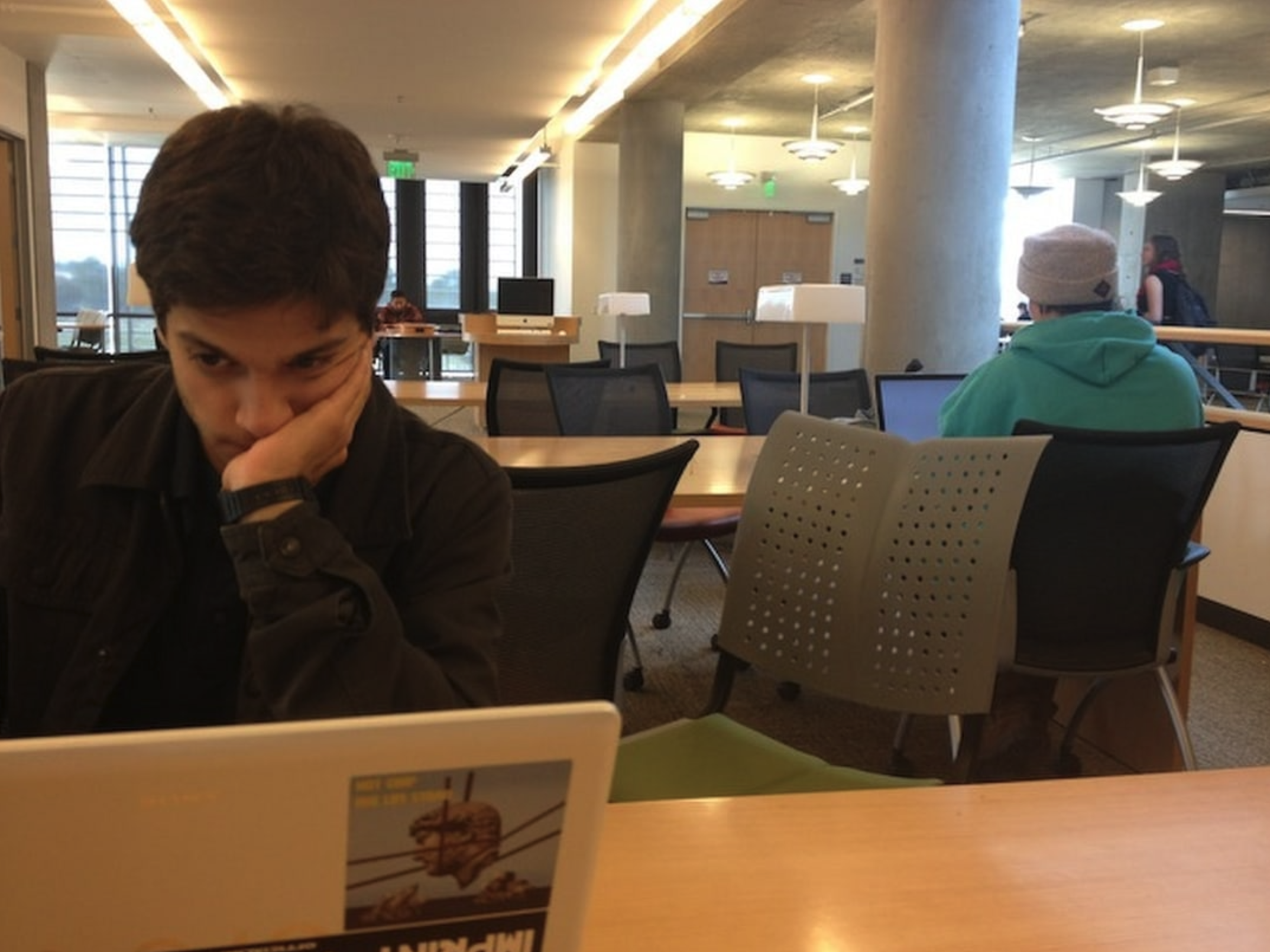 Michael Nazari studying at a laptop in the university library during his last week of college
